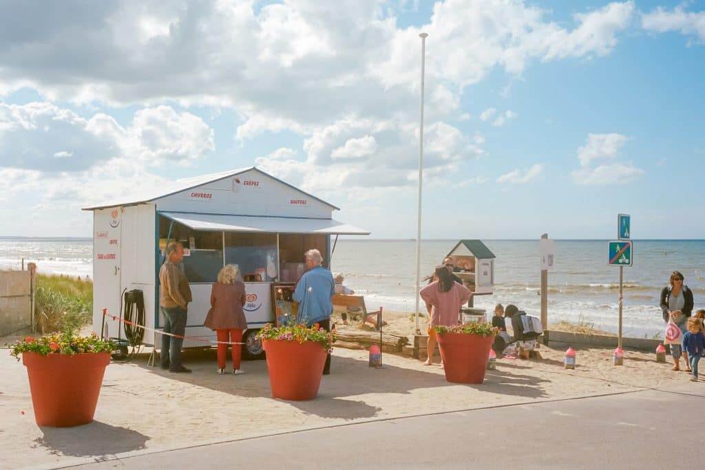 La plage de Cabourg, l'une des plus romantiques de la Côte fleurie - Photo de <a href="https://unsplash.com/fr/@pfgapais?utm_content=creditCopyText&utm_medium=referral&utm_source=unsplash">Paul-François Gapais</a> sur <a href="https://unsplash.com/fr/photos/personnes-assises-sur-un-banc-pres-dun-plan-deau-pendant-la-journee-hWOcsGTr5a8?utm_content=creditCopyText&utm_medium=referral&utm_source=unsplash">Unsplash</a>